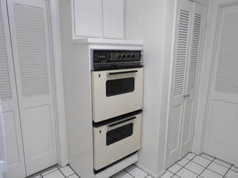 A white oven with a black stove top is in a kitchen.