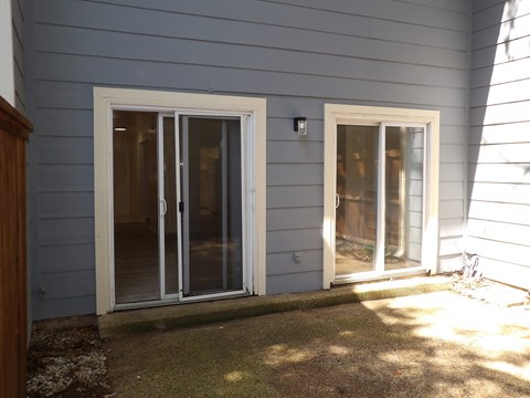 A house with a grey siding and a white door and window.