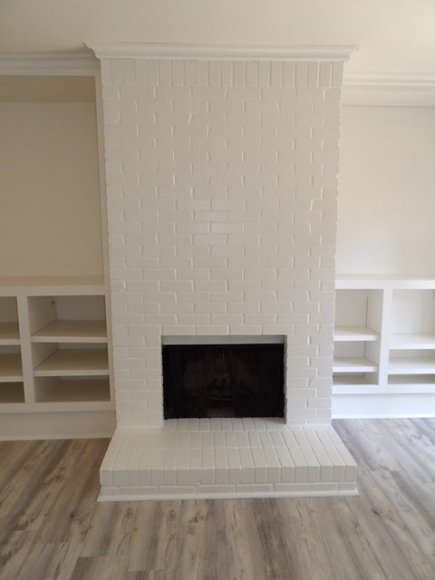 A white brick fireplace with a black fire place.