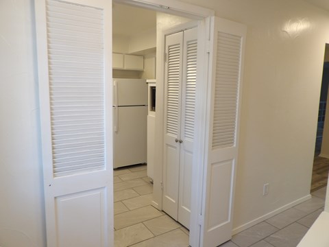 A kitchen with white cabinets and a refrigerator.