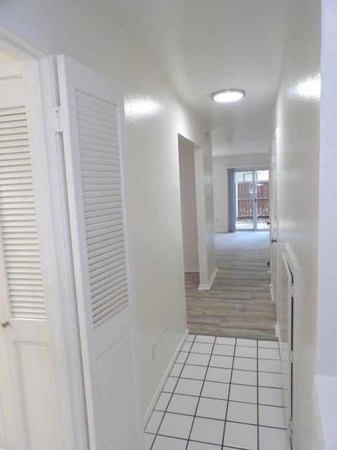 A long white hallway with a tiled floor.