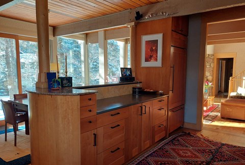 A kitchen with wooden cabinets and a large window.