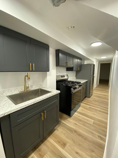 A kitchen with dark wood cabinets and a white marble countertop.