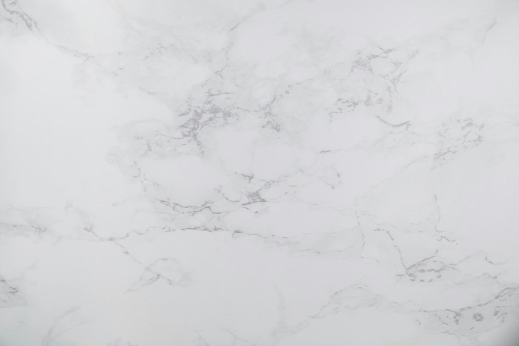 A close up of a white marble surface with natural veining.