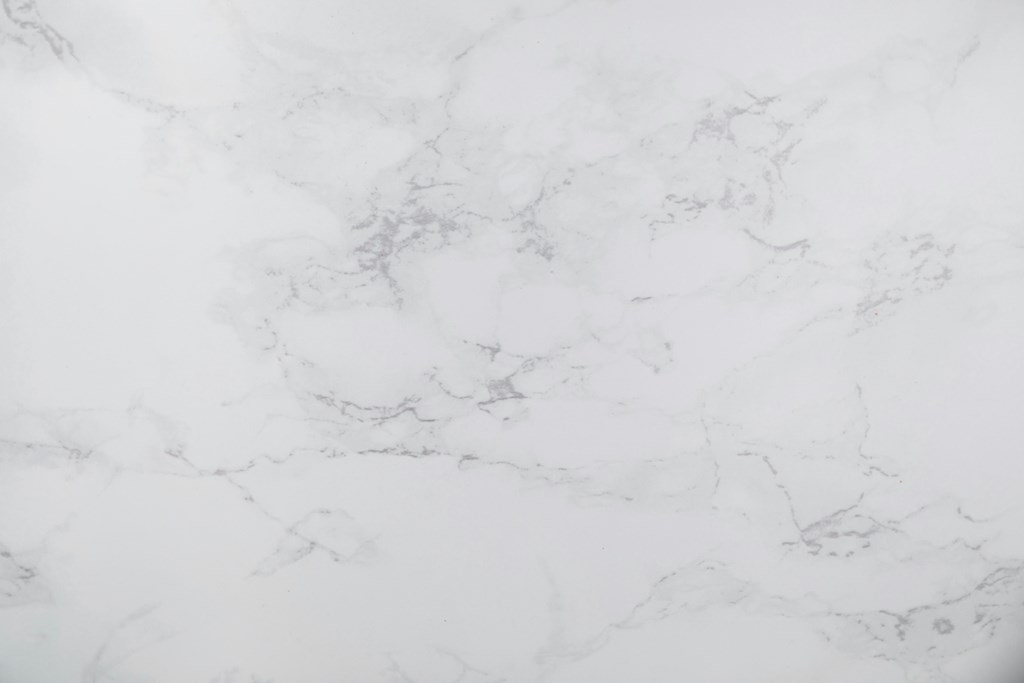 A close up of a white marble surface with natural veining.