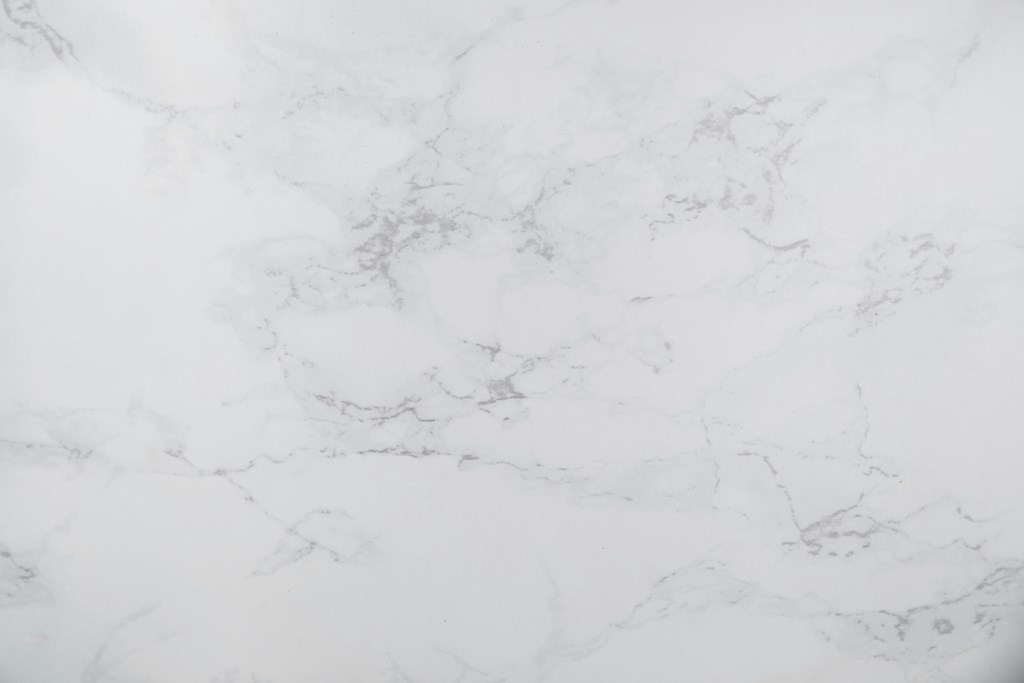 A close up of a white marble surface with natural veining.