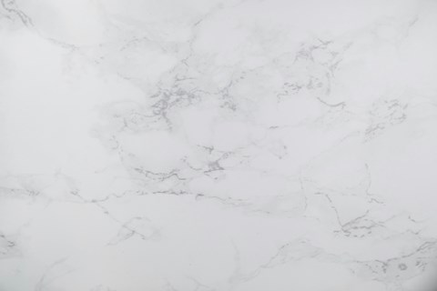 A close up of a white marble surface with natural veining.