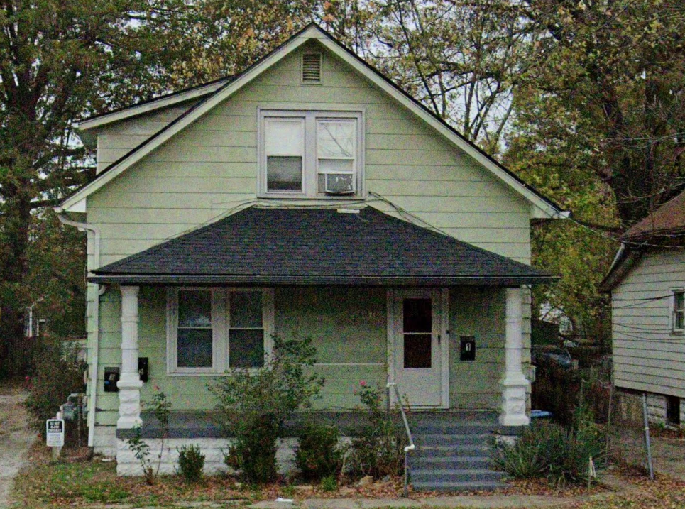 A small house with a porch and a front door.