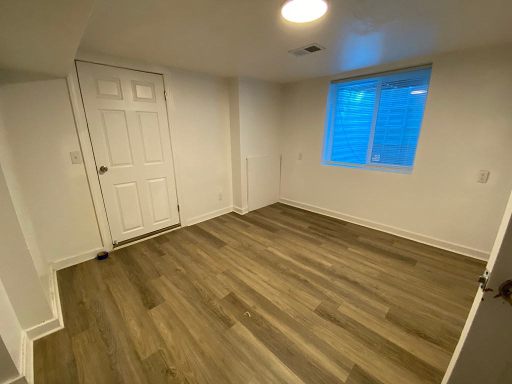 A room with a white door and a window with blinds.