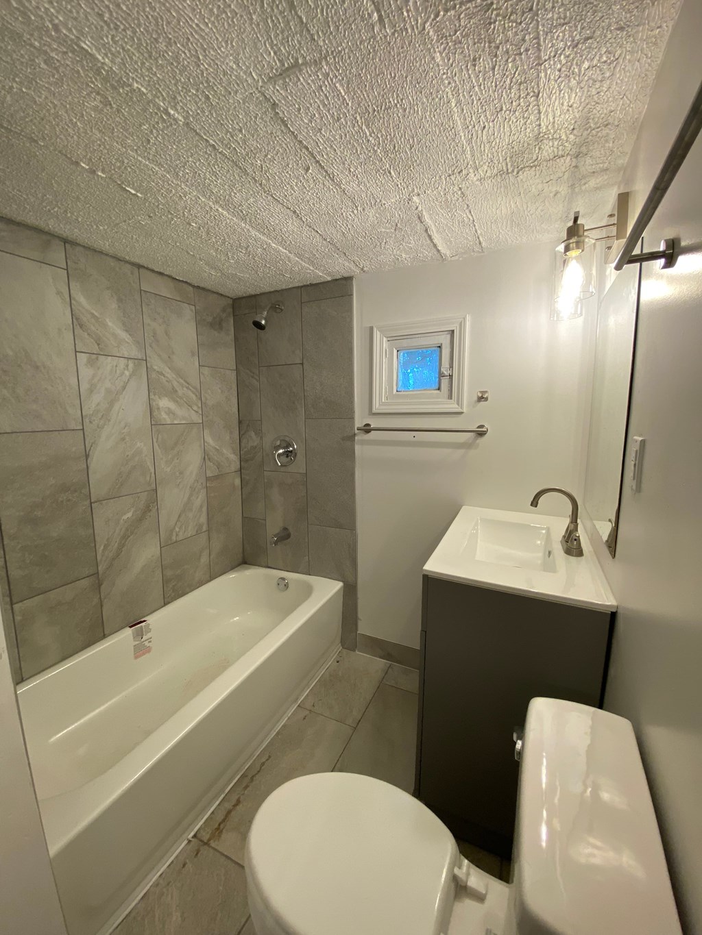 A bathroom with a white tub, toilet, and sink.