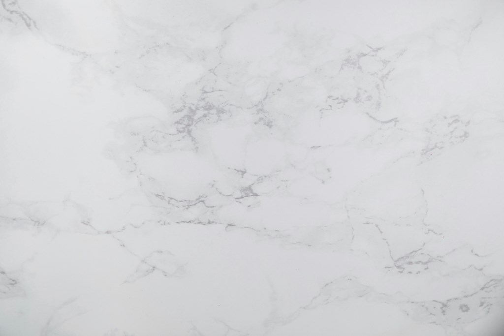 A close up of a white marble surface with natural veining.