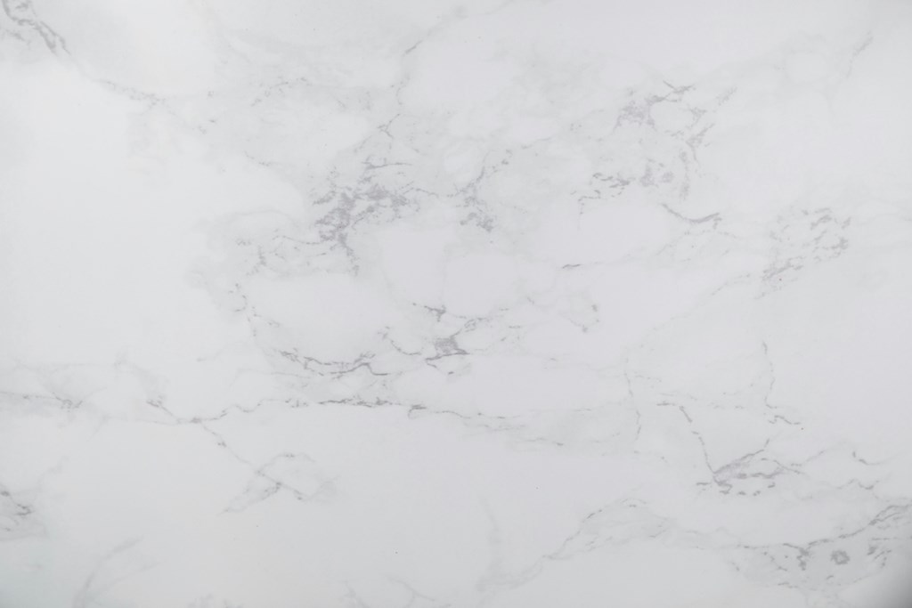 A close up of a white marble surface with natural veining.