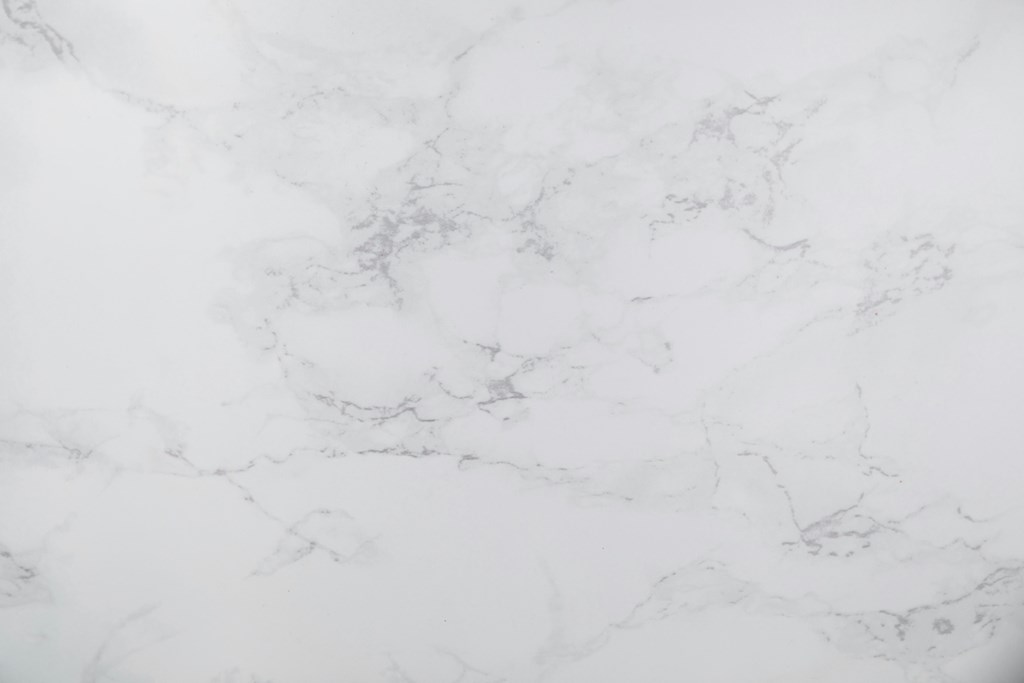 A close up of a white marble surface with natural veining.