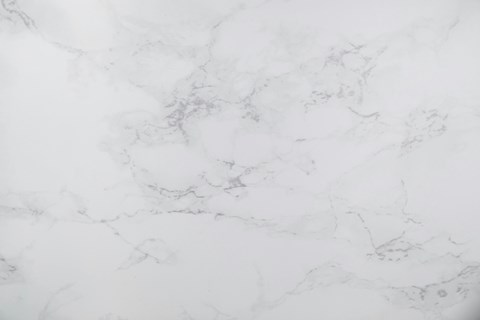 A close up of a white marble surface with natural veining.