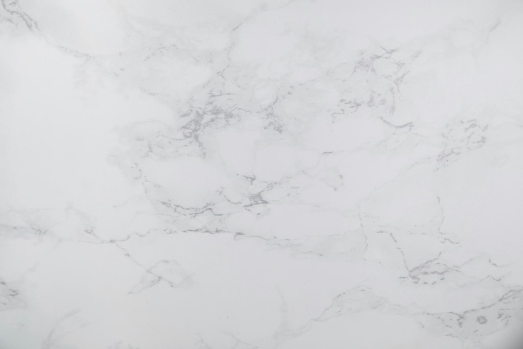 A close up of a white marble surface with natural veining.