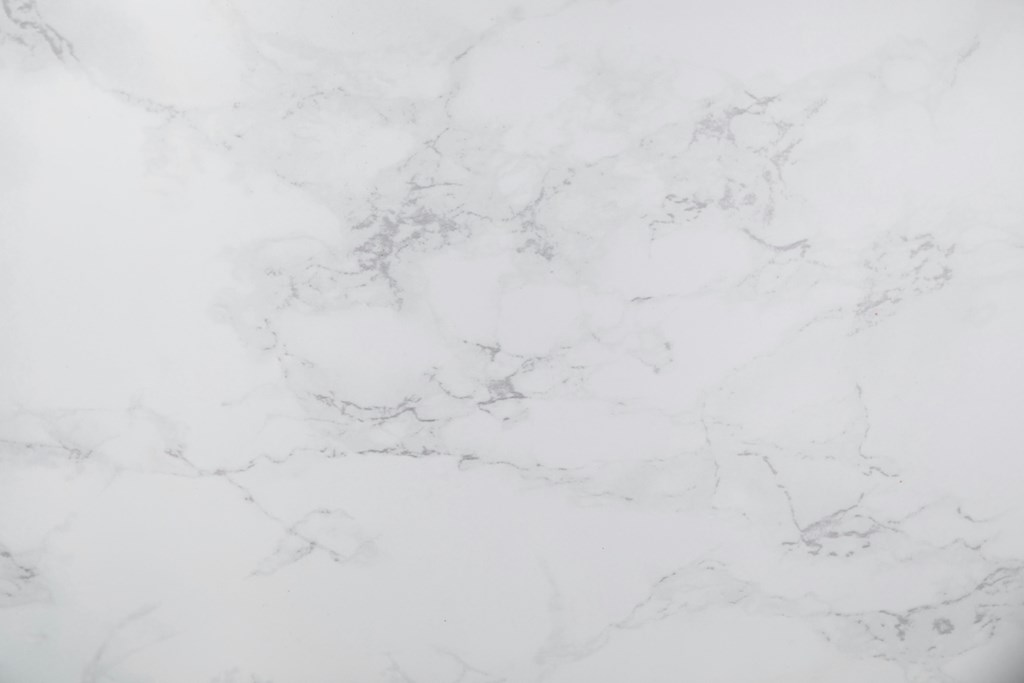 A close up of a white marble surface with natural veining.