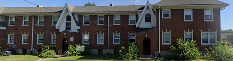 A red brick building with white trim and a black door.