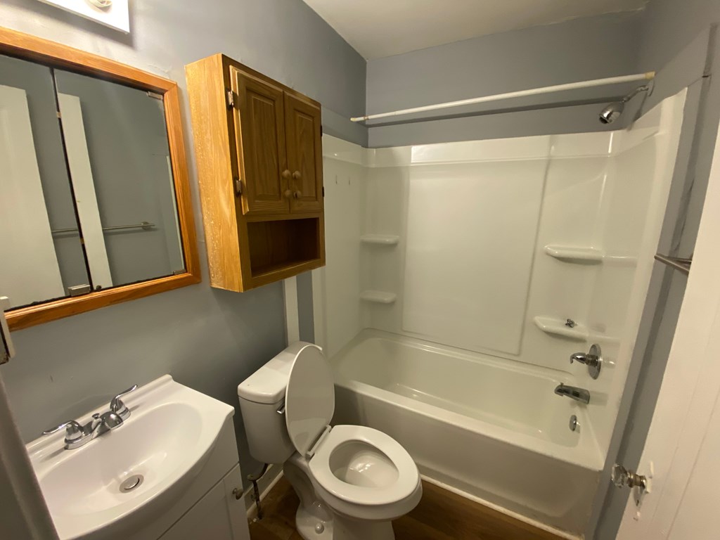 A bathroom with a toilet, sink, and bathtub.