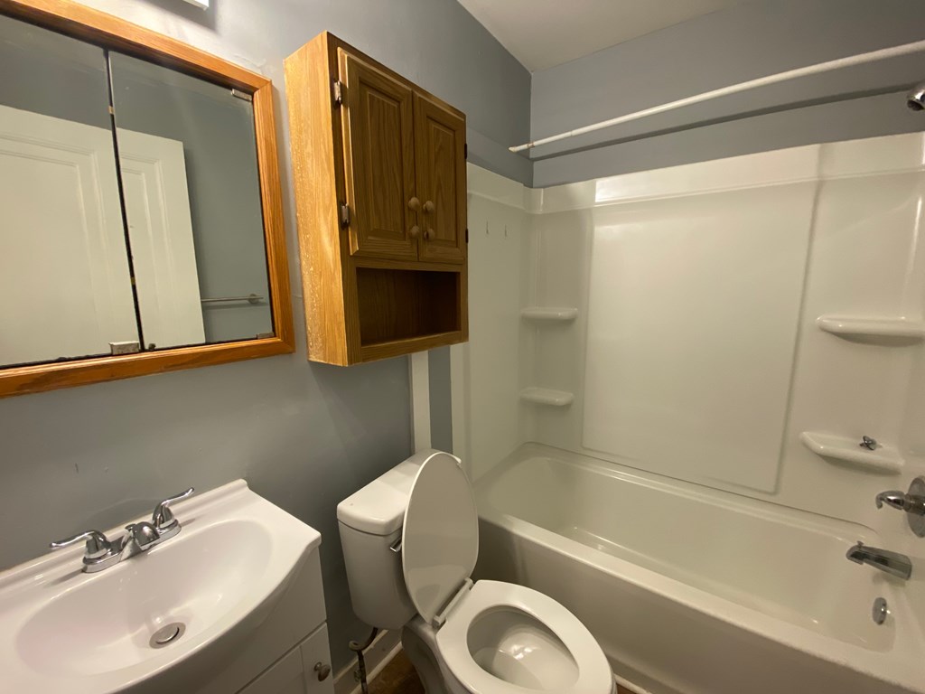 A bathroom with a toilet, sink, and bathtub.