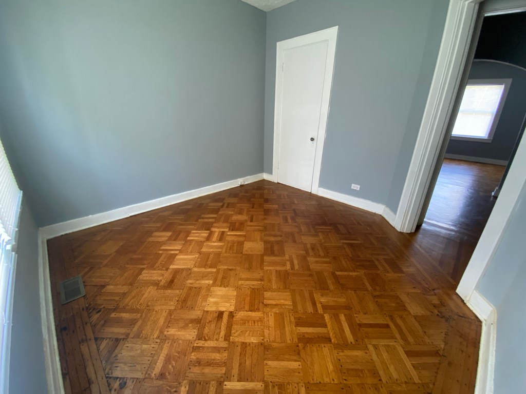 A room with a wooden floor and a white door.