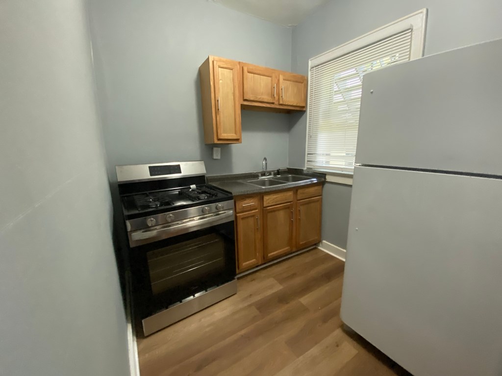 A kitchen with a stove, oven, and refrigerator.