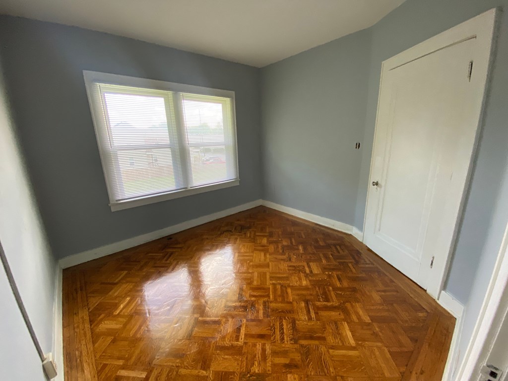 A room with a wooden floor and a window.