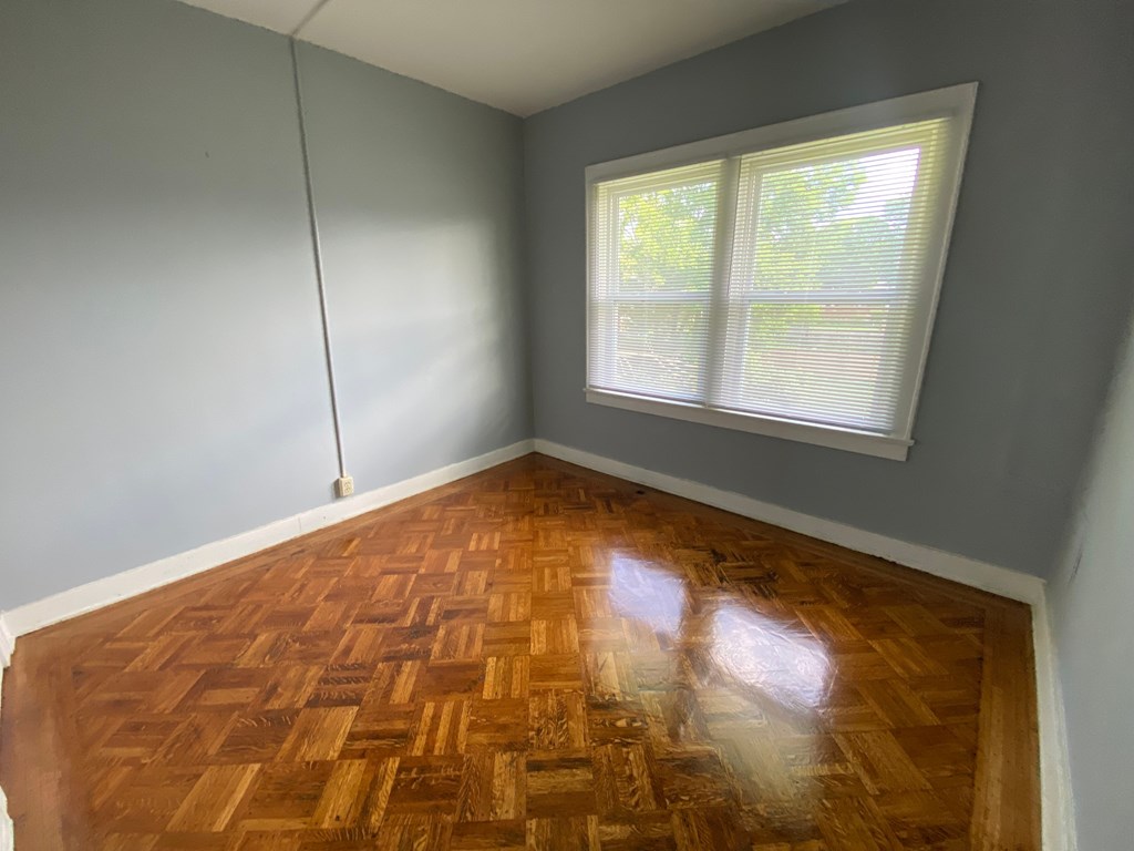 A room with a wooden floor and a window.