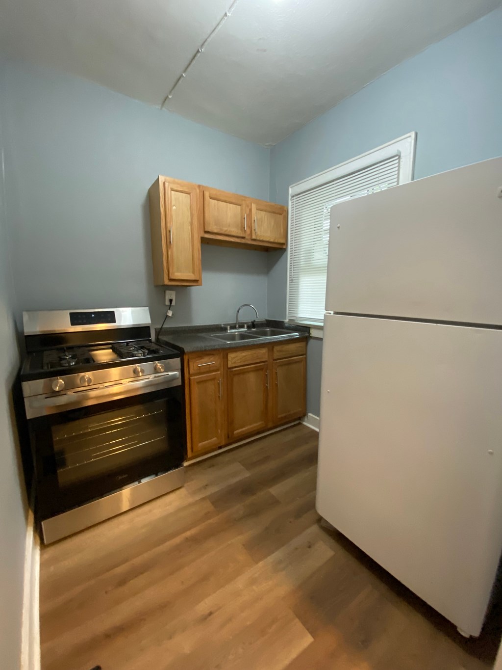 A kitchen with a white refrigerator, stove, and oven.