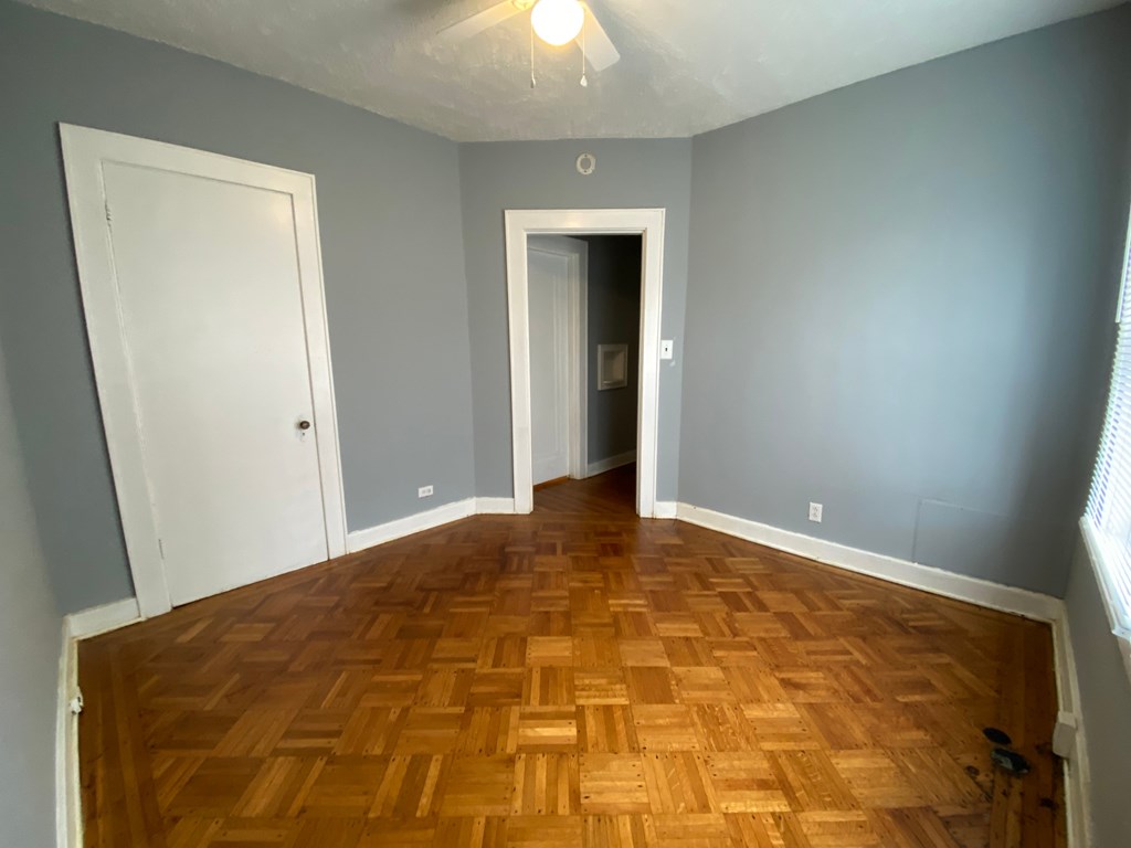 A room with wooden flooring and two doors.