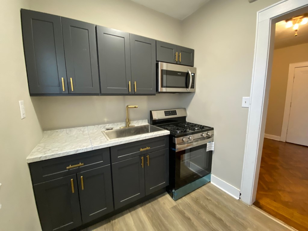 A kitchen with black cabinets and a white countertop.