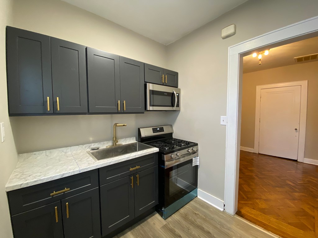 A kitchen with black cabinets and a white countertop.