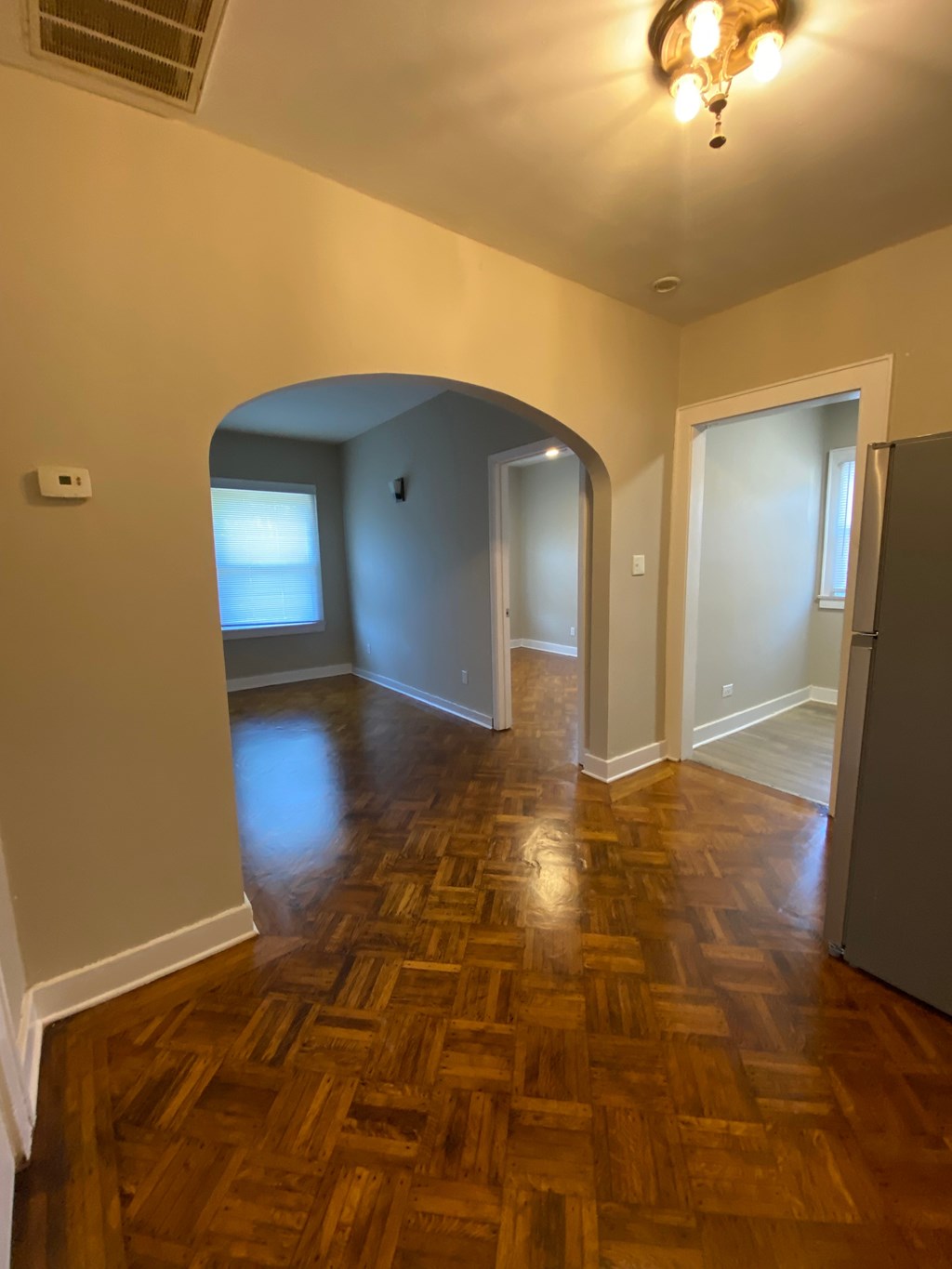 A room with a wooden floor and a chandelier.