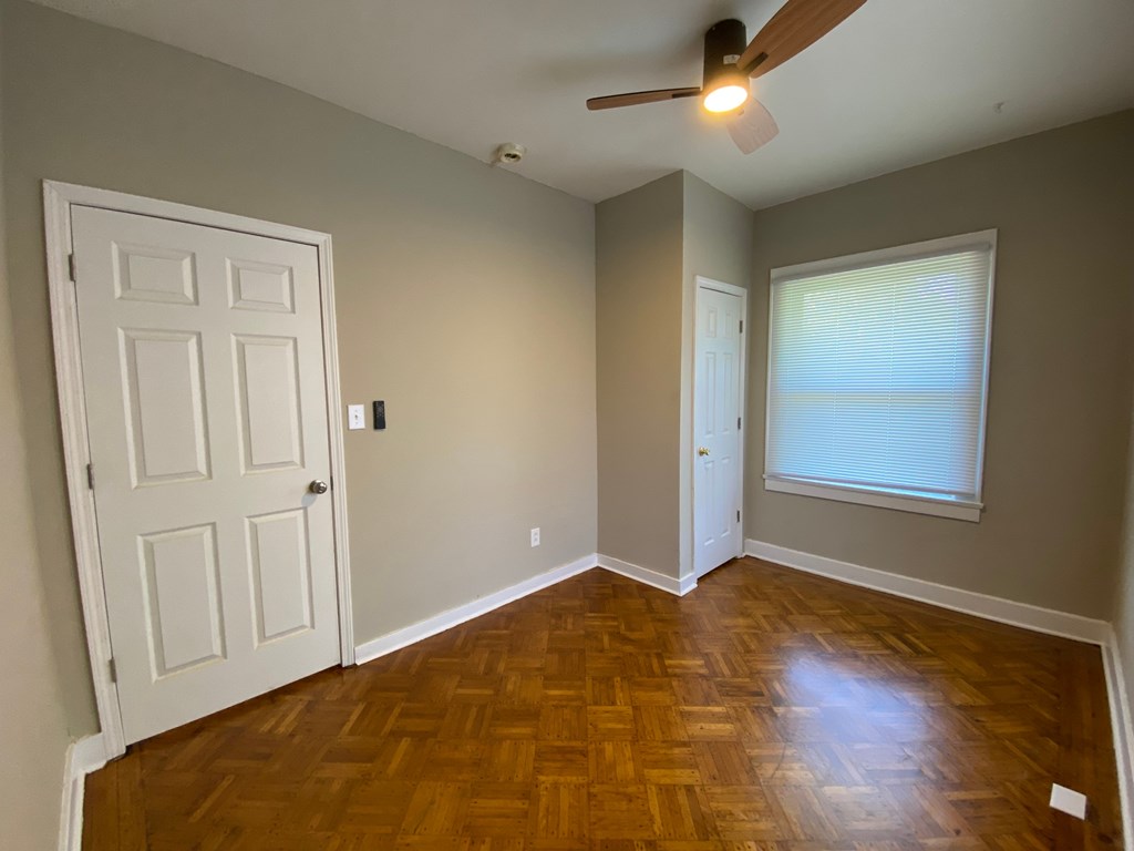 A room with a wooden floor and a ceiling fan.