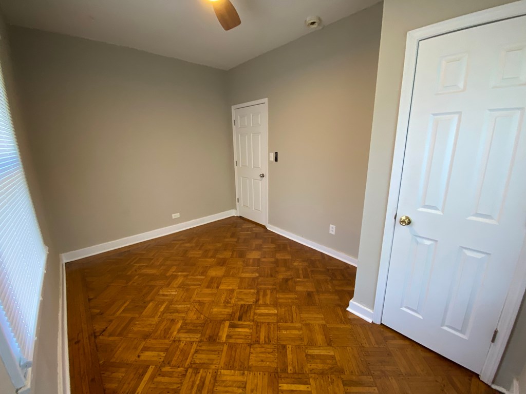 A room with a wooden floor and a white door.