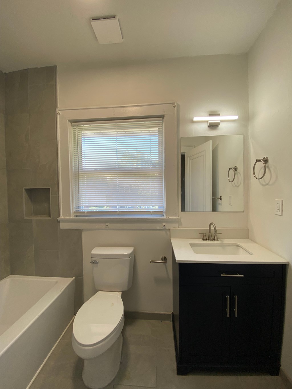 A white toilet sits next to a bathtub in a bathroom.
