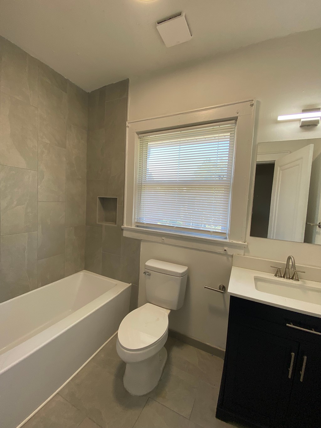 A white toilet sits next to a bathtub in a bathroom.