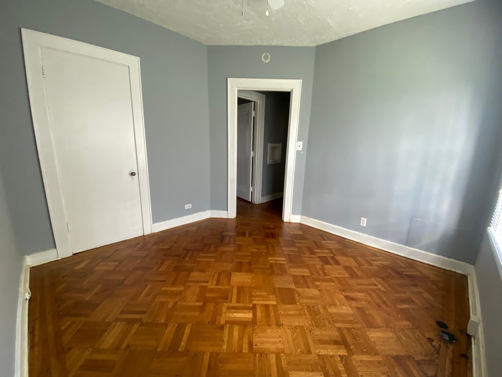 A room with a wooden floor and two doors.