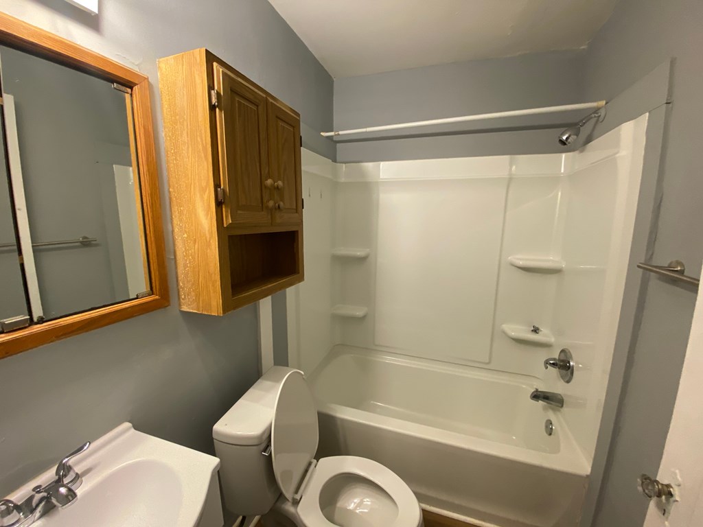 A bathroom with a toilet, sink, and bathtub.