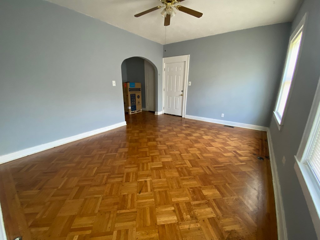 A room with a wooden floor and a ceiling fan.