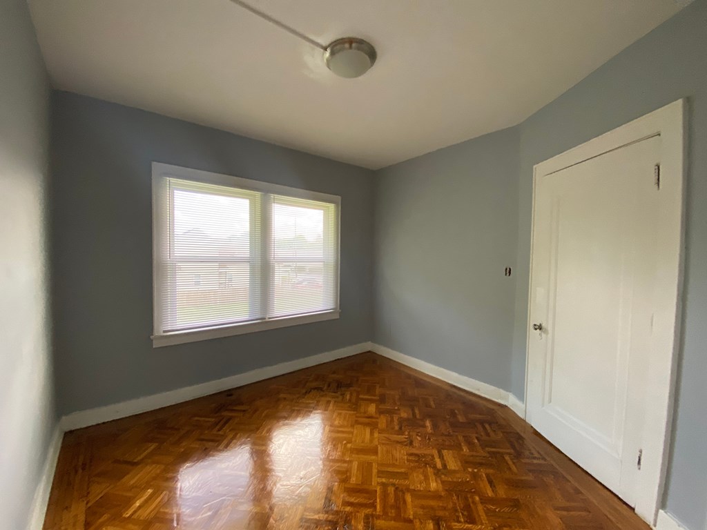 A room with a wooden floor and a window.