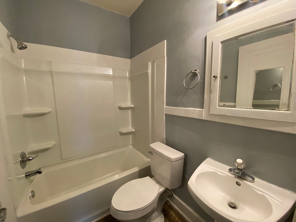 A white toilet sits next to a white sink in a bathroom.