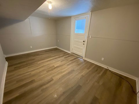 A room with wooden flooring and a white door.