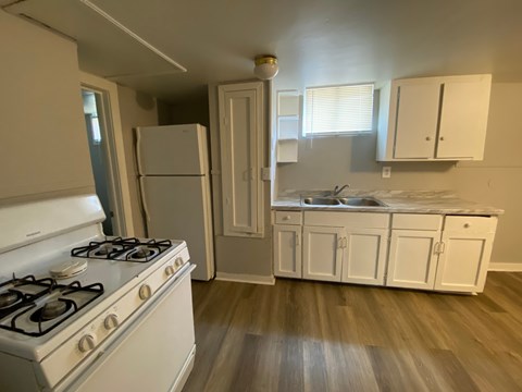 A kitchen with a white stove and cabinets.