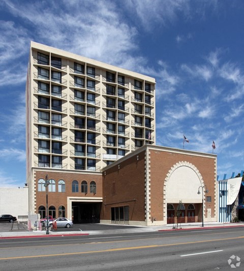 A large building with a flat roof and a balcony on the top floor.