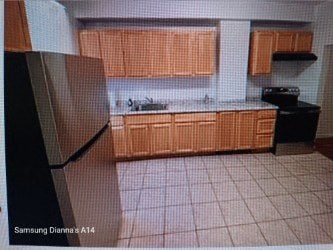 A kitchen with wooden cabinets and a black stove.