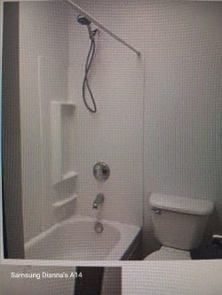 A white bathroom with a toilet and a shower.