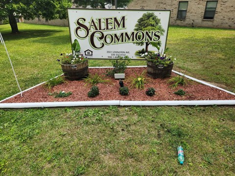 A sign that says Salem Commons is surrounded by plants.