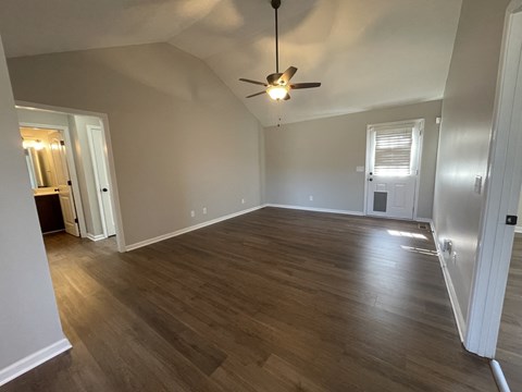 A room with wooden flooring and a ceiling fan.