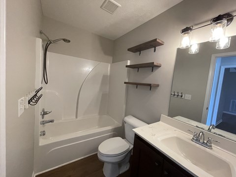 A white bathroom with a toilet, sink, and bathtub.