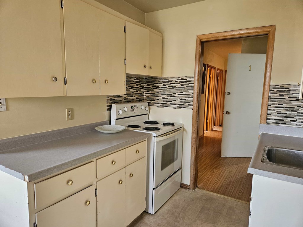 A kitchen with a stove top oven and a white dishwasher.